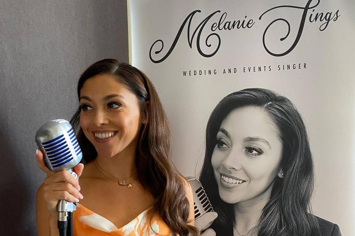 Melanie of Melanie Sings holding a vintage microphone